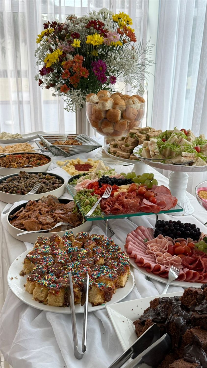 Buffet completo com flores, frios, saladas e pratos quentes